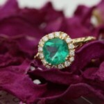 Gold ring with emerald centrepiece with diamonds surrounding it